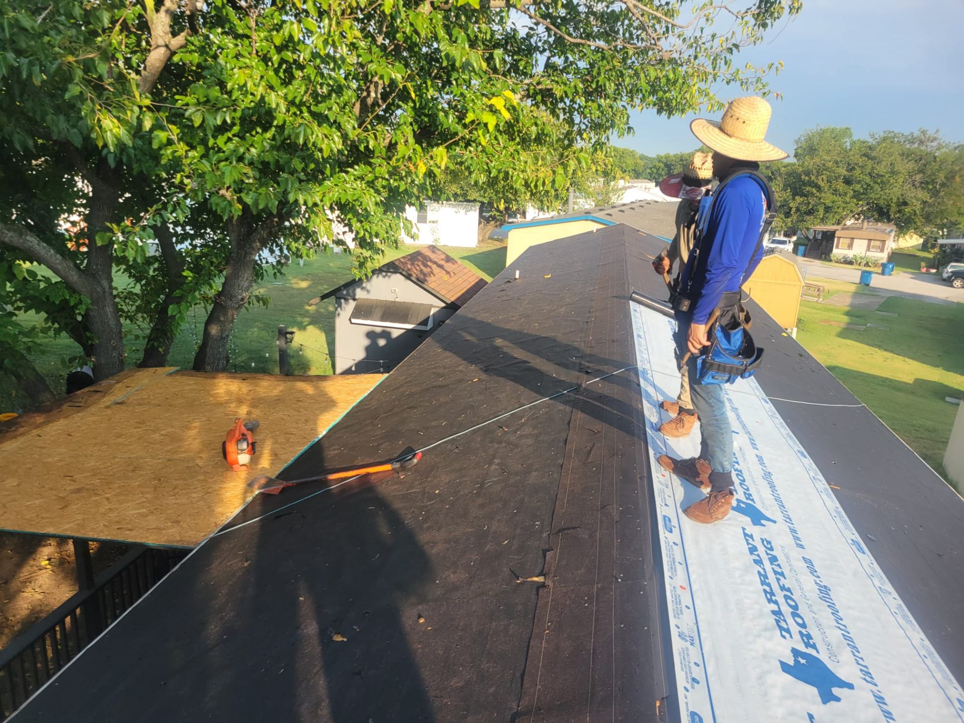 Técnico instalando underlayment en techo residencial