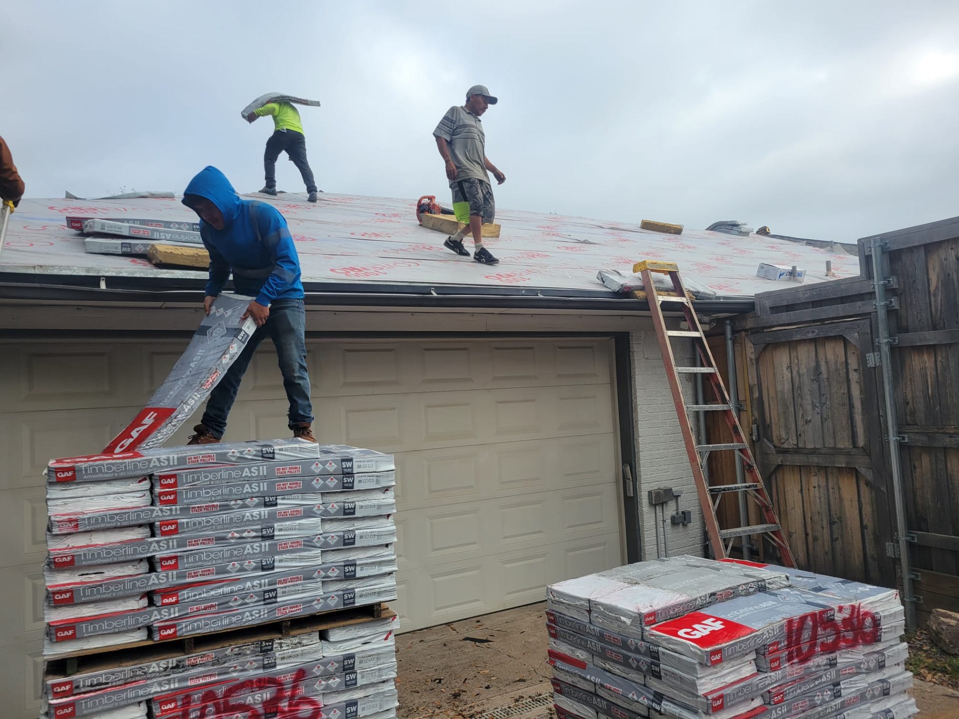Equipo cargando shingles GAF Timberline en obra